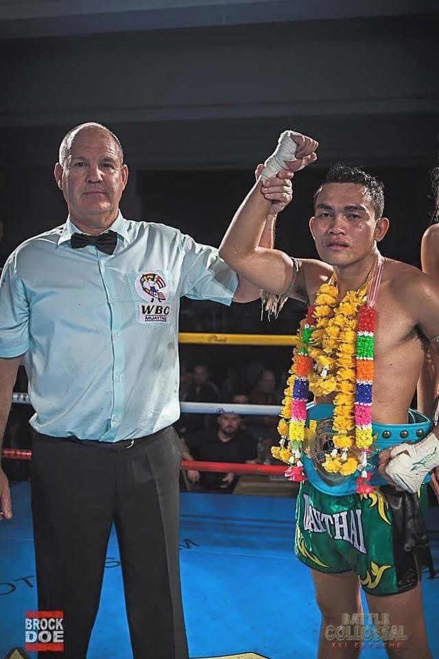 Surasak having his hand raised after a win